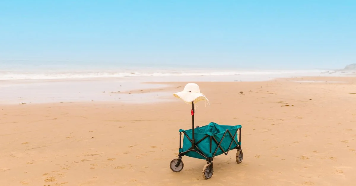 Plage paisible avec un chariot portant un chapeau de soleil, parfait pour une journée d'été relaxante.